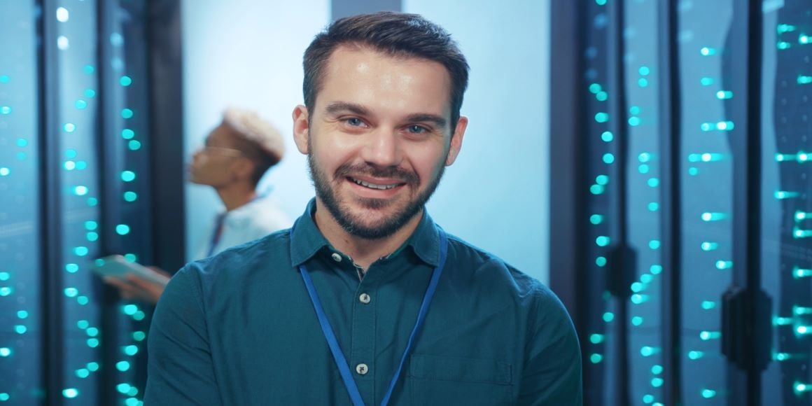 A smiling technician standing in a modular data center