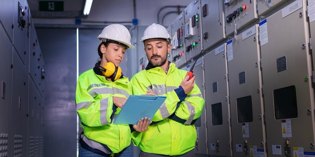 Two engineers working on a switchboard