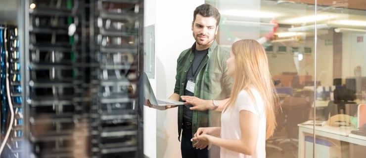 Man and woman talking in front of a server rack